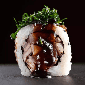 Uramaki Atum Negro — Atum selado, geleia de alho negro, crispy de couve e ovas de peixe