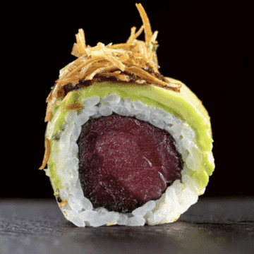 Uramaki Urakati — Uramaki envolto no Avocado, recheado com Atum, com o topo de Tarê, Pimenta Sriracha e Alho Poró Crocante