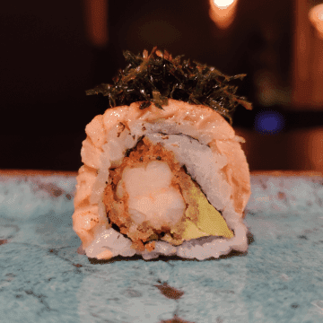 Uramaki Urawal — Camarão Empanado, Avocado, Alga Nori, Arroz por fora, Lâmina de salmão maçaricado por cima, Geleia de alho negro, Crispy de couve e Limão siciliano