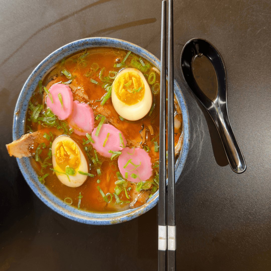 Shoyu Ramen — Caldo a base de Frango e Porco cozidos por 24h com Fino Corte de Pernil Grelhado com Barbacue Oriental, com Ovo Marinado, Narutomaki, Cebolinha, Nori e Óleo Aromatizado em Gengibre e Alho